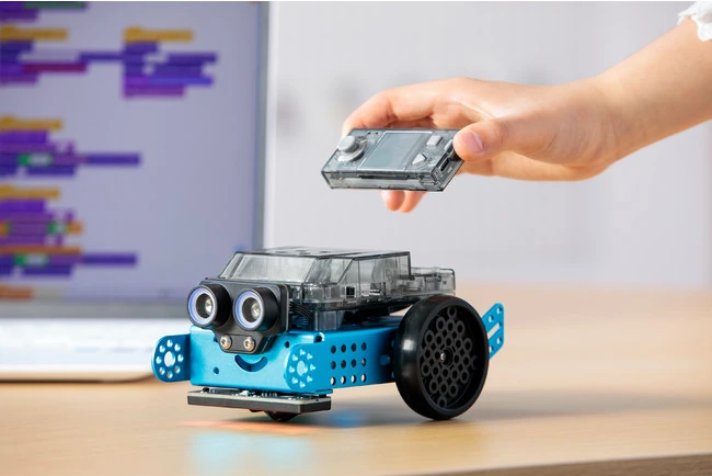 A blue mBot2 coding robot with its CyberPi controller being placed on top.
